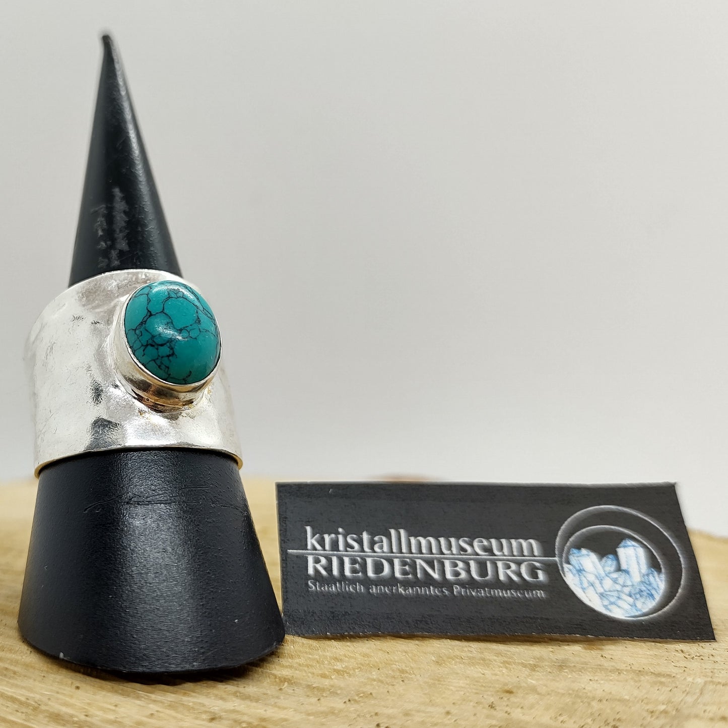 Runder Türkis-Cabochon in einer auffälligen Fassung aus gehämmertem Silber, rhodoniert, 1,8cm breit verlaufend.