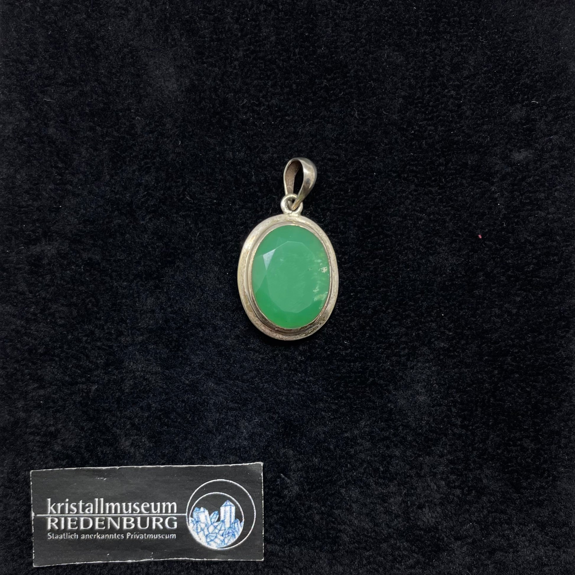 Ovaler, leicht durchsichtiger, stechend grüner, facettierter Chrysopras in breiter Silberfassung